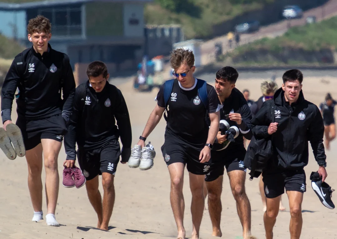 SSFC International Students walking barefoot on beach at North East coastline.
