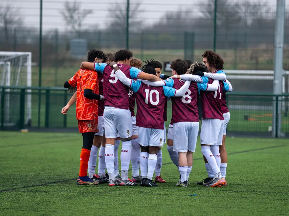 SSFC International Academy students huddled in a group discussing game plan.